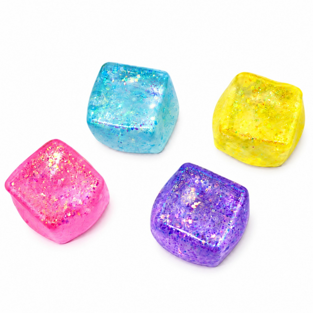 Fyra mjuka klämbollar med glitter i rosa, blått, gult och lila