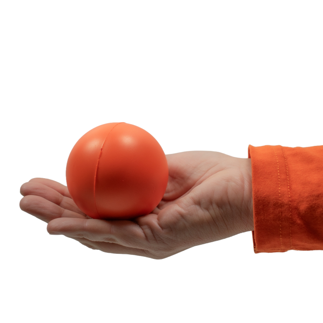 Orange rund stressboll visas i en öppen hand med orange tröja, mot vit bakgrund.