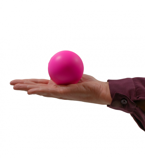 Cerise stressboll placerad i en öppen hand, visar storlek och form på bollen.