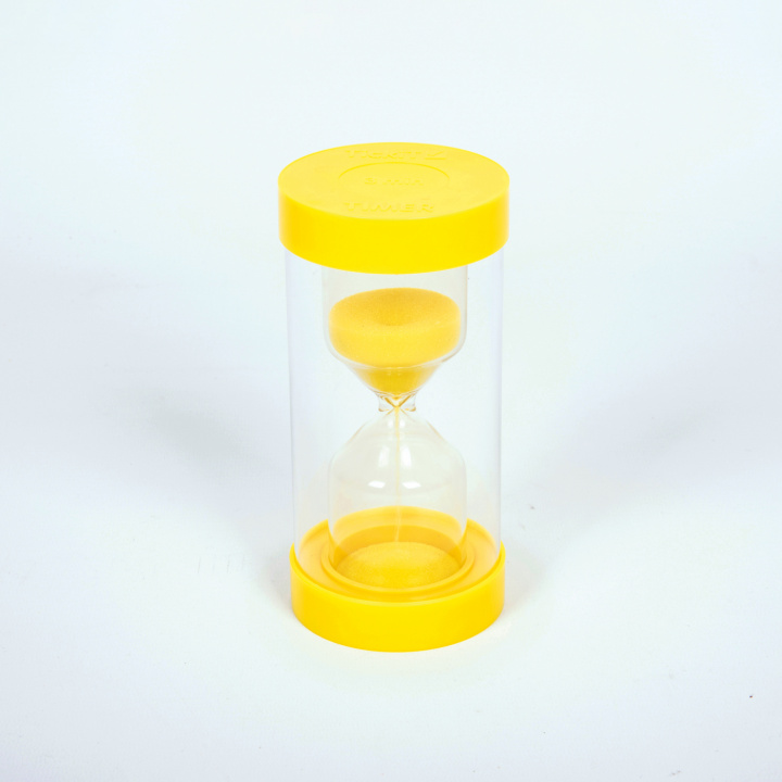 Timglas med gul sand, stående på vit bakgrund.