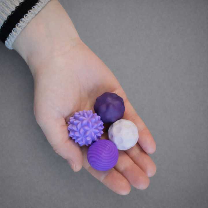 Fyra magnetiska sensoriska bollar med olika mönster och struktur